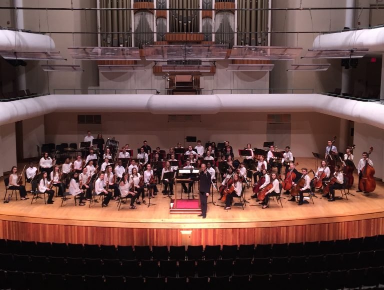 Amir Zaheri conducting an orchestra in Moody Concert Hall